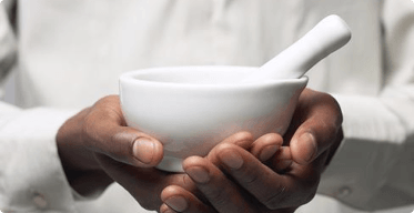 A hand holding a mortar and pestle